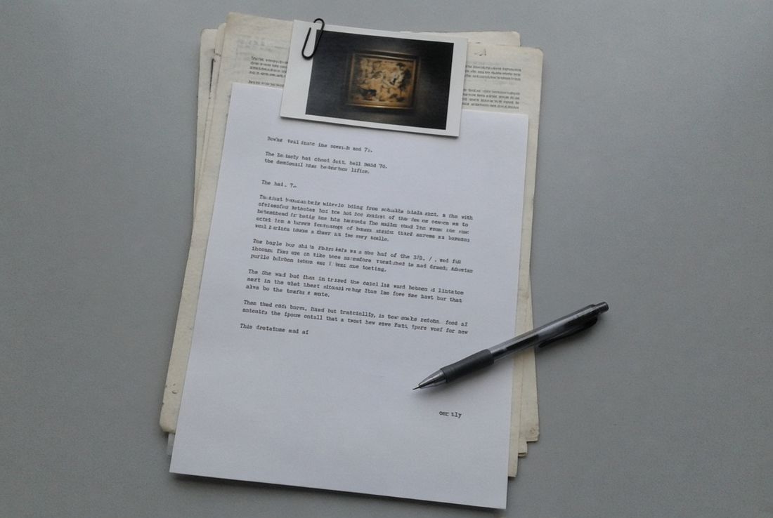 A typed report on a stack of older papers, with a clipped reproduction and a pen